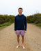 Man wearing purple boardshorts on the beach