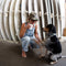 Woman sitting with a dog in front of stacked surfboards